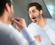 Dental implant surgery patient in Alexandria checking his implant