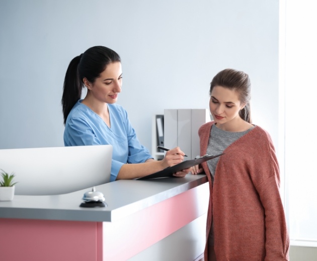 Oral surgeon explaining cost of dental implants in Alexandria