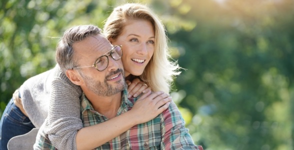 Man and woman smiling after tooth replacement with dental implants