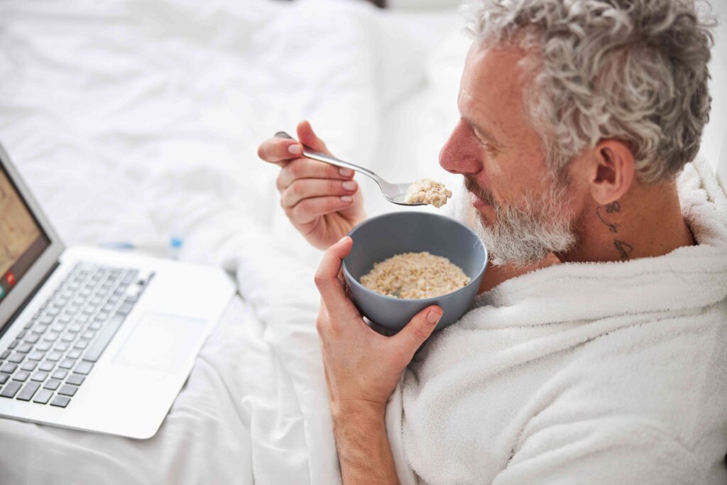 Man eating oatmeal in bed