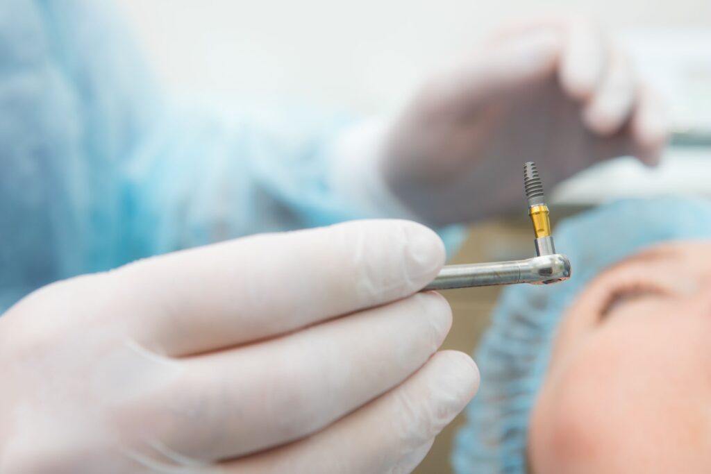Closeup of implant held by dentist during surgery
